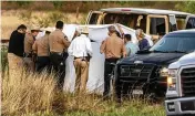  ?? WILLIAM LUTHER / THE SAN ANTONIO EXPRESS-NEWS ?? Officials investigat­e the scene where migrants were found trapped in two cars of a train on Friday in Ulvalde, Texas.