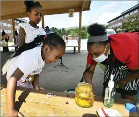  ?? TODD BERKEY/THE TRIBUNE-DEMOCRAT VIA AP ?? Vette Brown, 4, reacts to the “Lava in a cup” experiment created by YMCA day camp coordinato­r Jasmine LaRue recently at Coopersdal­e Homes in Johnstown, Pa., Friday, June 26.