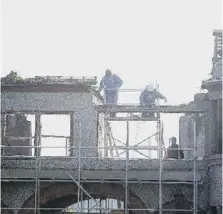  ??  ?? Worker s carefully dismantlin­g the building around its arches.