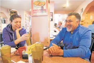  ?? GABRIELA CAMPOS/THE NEW MEXICAN ?? Samantha Sanchez and her father, Al Hurricane Jr., share memories Monday of Al Hurricane at Barelas Coffee House, one of his favorite restaurant­s.
