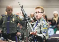  ?? Jessica Hill / Associated Press ?? Firearms training unit Det. Barbara J. Mattson, of the Connecticu­t State Police, holds up a Bushmaster AR15 rifle, the same make and model of gun used by the Sandy Hook School shooter.