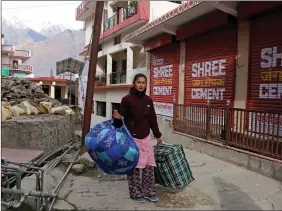  ?? ?? A resident shifts her belongings after the district administra­tion declared various houses unsafe following cracks due to land subsidence, at Joshimath, in Uttarakhan­d on 17 January 2023. ANI