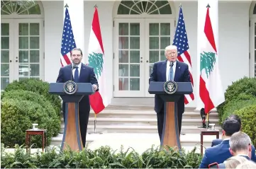  ?? — AFP photo ?? Trump holds a news conference with Hariri in the Rose Garden at the White House in Washington,DC.