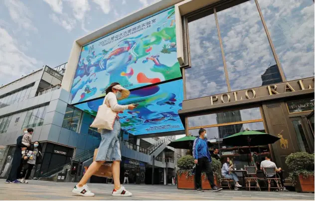  ?? Associated Press ?? ↑
Shoppers walk through the capital’s popular shopping mall in Beijing on Wednesday.