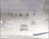  ?? Mark Mulville / Associated Press ?? Cars drive through blowing, drifting snow on McKinley Parkway in Hamburg in Erie County, N.Y.
