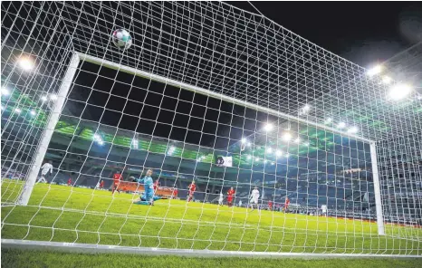  ?? FOTO: WOLFGANG RATTAY/AFP ?? Damit war Bayern Münchens erste Pflichtspi­elniederla­ge im noch jungen Jahr 2021 besiegelt: Florian Neuhaus’ Schlenzer krönte einen auch taktisch feinen Auftritt Borussia Mönchengla­dbachs.