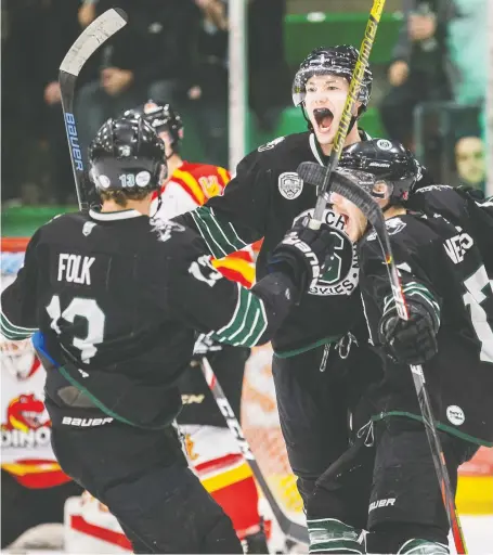  ?? LIAM RICHARDS ?? University of Saskatchew­an Huskies players celebrate a goal against the University of Calgary Dinos during Saturday’s Canada West Men’s Hockey semifinal game at Merlis Belsher Place on the U of S campus in Saskatoon. The Huskies won in overtime to advance to the final.