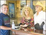  ?? (NWA Democrat-Gazette/Susan Holland) ?? Gravette dentist Kent Leonard (left), whose office is on Main Street, pauses for a photo with Lisa and D. Arthur Wilson at their Art Gone Wild art studio just down the street from his office. Leonard came out for the activities at the gallery walk and dropped in to visit with the Wilsons, organizers of the monthly events.