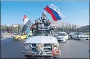  ?? HASSAN AMMAR — THE ASSOCIATED PRESS ?? Government supporters wave Syrian, Iranian and Russian flags Saturday as they chant slogans against U.S. President Trump during demonstrat­ions in Damascus, Syria.