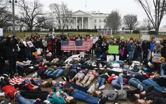  ?? OLIVIER DOULIERY/ABACA PRESS/TRIBUNE NEWS SERVICE ?? Students stage a “lie-in” outside the White House Monday. They remained still for three minutes to symbolize the time it took alleged shooter Nikolas Cruz to gun down his victims.