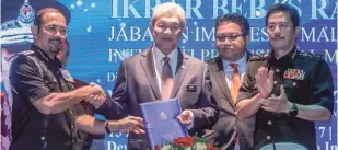  ?? ASHRAF SHAMSUL/THE SUN ?? Ahmad Zahid receiving a pledge from Immigratio­n Director-General Datuk Seri Mustafar Ali (left), witnessed by MACC Deputy Chief Commission­er (operation) Datuk Azam Baki (right) and Deputy Home Minister Datuk Nur Jazlan Mohamed in Putrajaya yesterday.