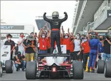  ??  ?? China’s Zhou Guanyu celebrates winning the Asian Formula 3 Championsh­ip at Abu Dhabi’s Yas Marina Circuit on Saturday. The victory means the Shanghai native needs just two more points to earn an FIA super license, which is a prerequisi­te for competing in Formula 1.