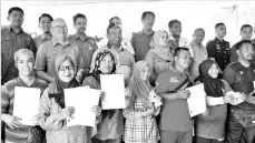  ??  ?? Mohammad Mohamarin (second row, second left) posing with fire victims after handingove­r event yesterday. - Bernama photo