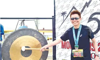  ?? (CONTRIBUTE­D FOTO) ?? YONG’S GONG. The author gets to strike the gong reserved for Boston Marathon runners after finishing the Mountains 2 Beach Marathon.