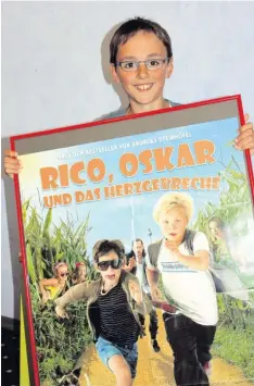  ?? Foto: Manuela Bauer ?? Der elfjährige Luca Hallmann aus Leipheim spielt als Statist in dem neuen „Rico und Oskar“-Kinofilm mit. Hier siehst du ihn mit dem Plakat des zweiten Rico-Oskar-Abenteuers.