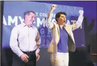  ??  ?? Amy McGrath, right, with her husband, Erik Henderson, pumps her fists.