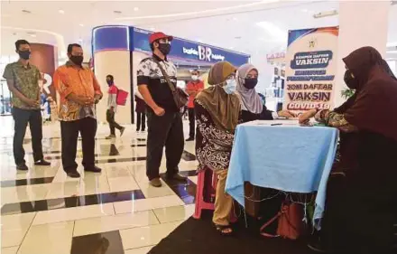  ?? PIC BY GHAZALI KORI ?? People registerin­g for the Covid-19 vaccine at a mall in Kuala Terengganu on Thursday.