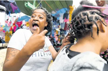  ?? GLADSTONE TAYLOR/MULTIMEDIA PHOTO EDITOR ?? Nastassia Findley says the COVID-19 pandemic is set to ruin Christmas for her and her family. As she combed a customer’s hair in downtown Kingston yesterday, she also lamented the cancellati­on of the year end fireworks on the Waterfront.