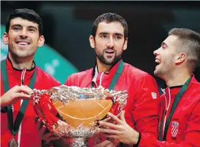  ?? — THE ASSOCIATED PRESS ?? Croatia’s Marin Cilic, centre, holds the Davis Cup with teammates Franko Skugor, left and Borna Coric after beating France 3-1 in Sunday’s final in France.