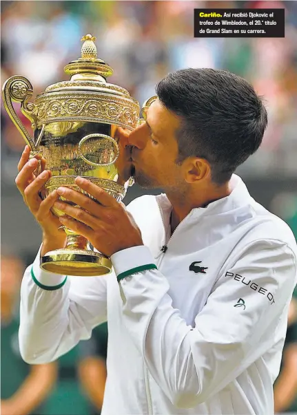  ??  ?? Cariño. Así recibió Djokovic el trofeo de Wimbledon, el 20.° título de Grand Slam en su carrera.
