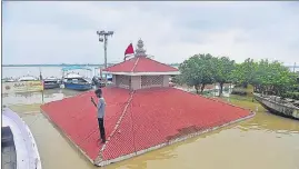  ??  ?? A nearly submerged temple on the bank of the Ganga r, following heavy rain in Varanasi on Tuesday.