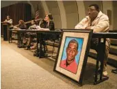  ?? LOREN ELLIOTT/AP ?? Andrew Joseph Jr. sits behind a picture of his deceased son, Andrew Joseph III, at a Black Lives Matter forum at John Germany Library in Tampa on Sept. 9, 2015.