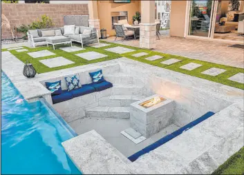  ?? Realty ONE Group ?? The home features a resort-style backyard with a sunken seating area next to the pool. A large fire feature is the central focal point.