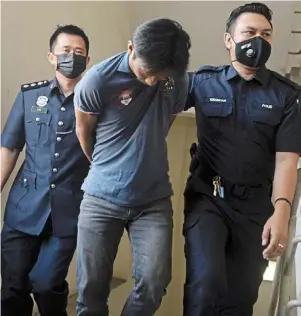  ?? — ss KaNEsaN/The star ?? Facing the law: Police officers escorting Mohamed Badruldin to the Magistrate’s Court in Petaling Jaya.