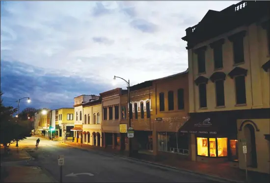  ??  ?? In this file photo, the storefront window of a portrait studio is lit up along a downtown street at dusk in Lumberton, NC. The Community Reinvestme­nt Act has over past four decades spurred hundreds of billions of dollars in lending to low- and middle-income communitie­s. Now, the Trump administra­tion is proposing changes that some community advocates say will make it easier
for banks to meet the law’s criteria without making the types of loans that are most beneficial to the communitie­s they serve. (AP)