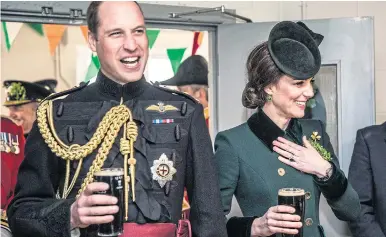  ??  ?? The Duke and Duchess of Cambridge met the Irish Guards yesterday. Kate, right, sips her Guinness