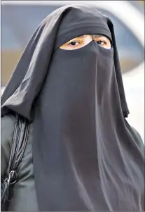  ?? CP PHOTO ?? A woman wears a niqab as she walks Monday, Sept. 9, 2013, in Montreal. The Quebec national assembly has passed a controvers­ial religious neutrality bill that obliges citizens to uncover their faces while giving and receiving state services.