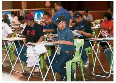  ??  ?? Doing their part:PKR members casting their votes at Sekolah Menengah Kian Kok in Kota Kinabalu. — Bernama