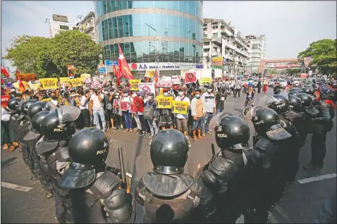  ?? (File Photo/AP) ?? Anti-coup protesters face a row of riot police in Yangon, Myanmar.