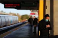  ?? ANDA CHU — STAFF PHOTOGRAPH­ER ?? Daniel Xie, wearing a mask, waits for a BART train on a nearly empty platform at the Union City station on Tuesday.