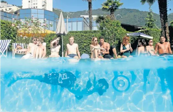  ??  ?? Un grupo de bañistas comparte una piscina antes de la crisis del coronaviru­s sin mantener la distancia de seguridad.