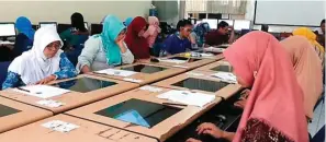  ?? FOTO: BRIANIKA IRAWATI/ JAWA POS ?? BERBASIS ONLINE: Peserta PPG semangat mengerjaka­n soal pretest di SMAN 15.