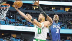  ?? John Raoux
The Associated Press ?? Celtics forward Jayson Tatum soars to the basket past Magic guard Terrence Ross during Boston’s 126120 victory Saturday at Amway Center. Tatum had 40 points.