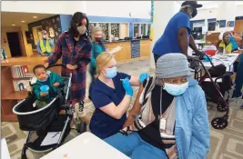  ?? Christian Abraham / Hearst Connecticu­t Media ?? Norwalk Hospital nurse Mallory Bates administer­s a COVID-19 vaccine to Elizabeth Jackson at Brien McMahon High School in Norwalk on March 20.