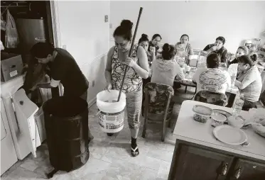  ?? Fotos de Julio Cortez / AP ?? Minerva Muñoz Nava (izq.) saca ropa de una secadora mientras Olga Covarrubia­s limpia y otras mujeres comen al final su jornada como trabajador­as temporales en Fishing Creek, Maryland, el jueves 14 de mayo.