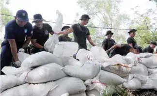  ??  ?? General operations force personnel placing sand bags to act as bunds against the possible high tides in Kampung Tok Muda, Kapar, Selangor.