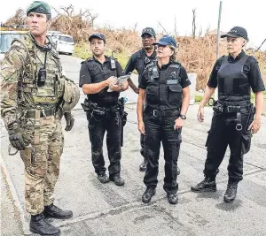  ??  ?? Major Tom Quinn of 40 Commando and UK Police lead Supt Sharon Bush, second right, as British Royal Marines and police assist in an operation to secure the inmates of Balsam Ghut prison, in Tortola. Picture: PA.