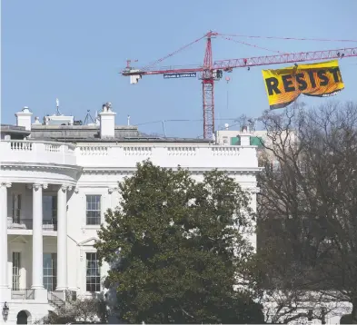  ?? ANDREW HARRER / BLOOMBERG FILES ?? Greenpeace activists hang a banner near the White House in 2017. U.S. President Donald Trump was able to secure a key
permit for the 1,950-kilometre Keystone XL pipeline, which would transport crude from Alberta to Nebraska.
