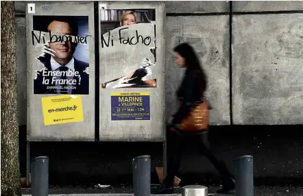  ?? Damien Meyer/AFP ?? Cartazes em Rennes (noroeste da França) exibem pixação ‘nem banqueiro’, para Macron, ‘nem fascista’, para Le Pen