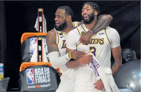  ?? Mark J. Terrill, The Associated Press ?? Los Angeles’ LeBron James ( 23) and Anthony Davis ( 3) celebrated an NBA championsh­ip on Sunday night. When they will get a chance to defend it is anybody’s guess.