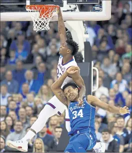  ?? CHARLIE NEIBERGALL — THE ASSOCIATED PRESS ?? Silvio De Sousa of Kansas and Duke’s Wendell Carter Jr. get tangled up under the basket during the first half of Saturday’s Midwest Regional final victory by the Jayhawks.