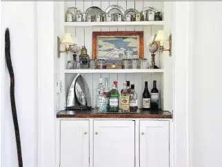  ?? KATHERINE FREY/WASHINGTON POST ?? Some of the family’s sailing awards and trophies are displayed on a built-in bar, which stands out against the fresh, crisp white walls Zantzinger chose for the space in Maryland.