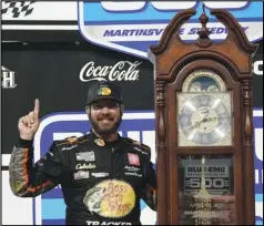  ?? Associated Press ?? TRUEX TIME — Martin Truex Jr. (19) celebrates with the winners’ trophy after winning the NASCAR Cup Series race at Martinsvil­le Speedway in Martinsvil­le, Va., on Sunday.