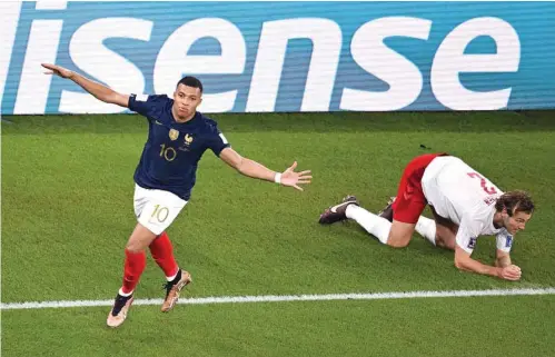  ?? (AFP) ?? France’s forward Kylian Mbappe celebrates scoring his team’s first goal as Denmark’s defender Joachim Andersen reacts during the Qatar 2022 World Cup Group D match at Stadium 974 in Doha yesterday.