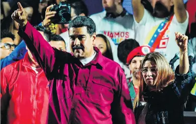  ?? JUAN BARRETO / AFP / GETTY IMAGES ?? Venezuelan President Nicolas Maduro, left, and his wife and first lady Cilia Flores gesture after the National Electoral Council declared Maduro the winner in Sunday’s presidenti­al election.