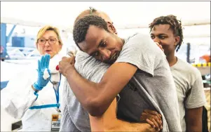  ?? AP PHOTO ?? Migrants say goodby to an aid worker as they disembark from the Open Arms aid boat, of Proactiva Open Arms Spanish NGO, after arriving at the port of Barcelona, Spain, Wednesday.